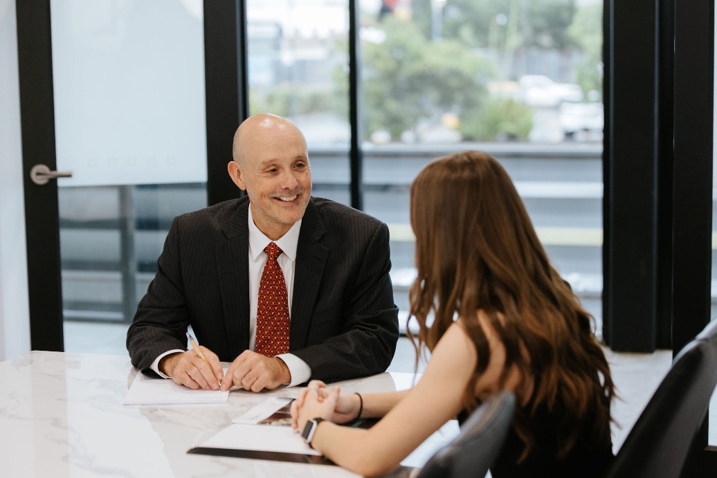 Smiling lawyer in suit talking to brunette female