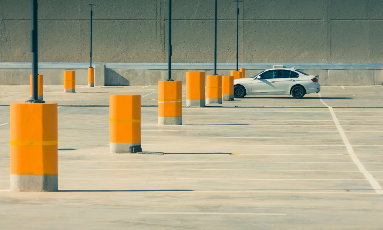 White car in a large empty carpark