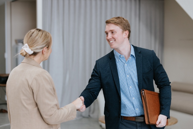 man in suit shaking hands with blond woman