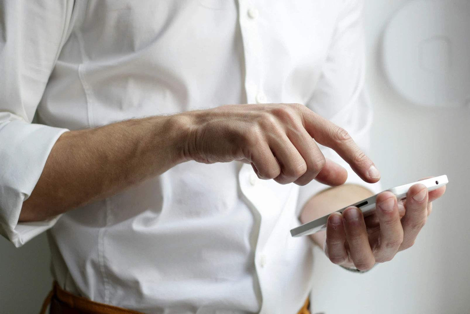 Man in dress shirt touching his phone