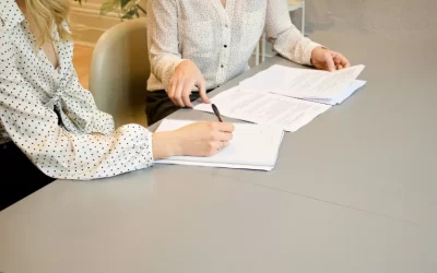 Legal paperwork on table with hands pointing to documents