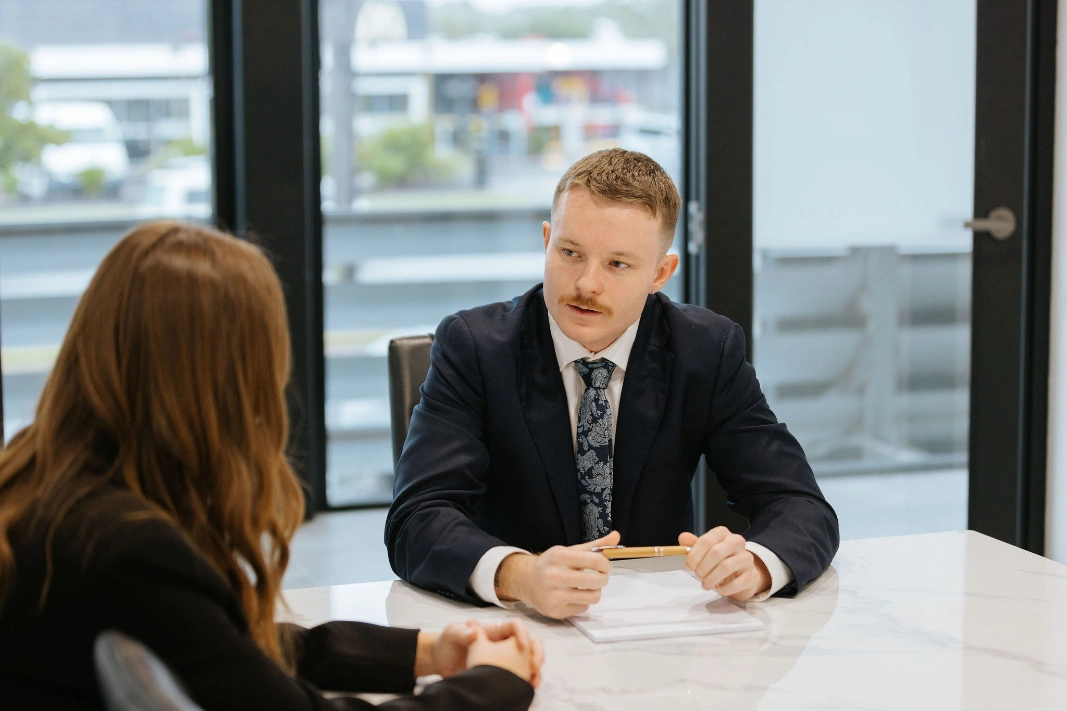 Professional man with moustache talking to brunette woman