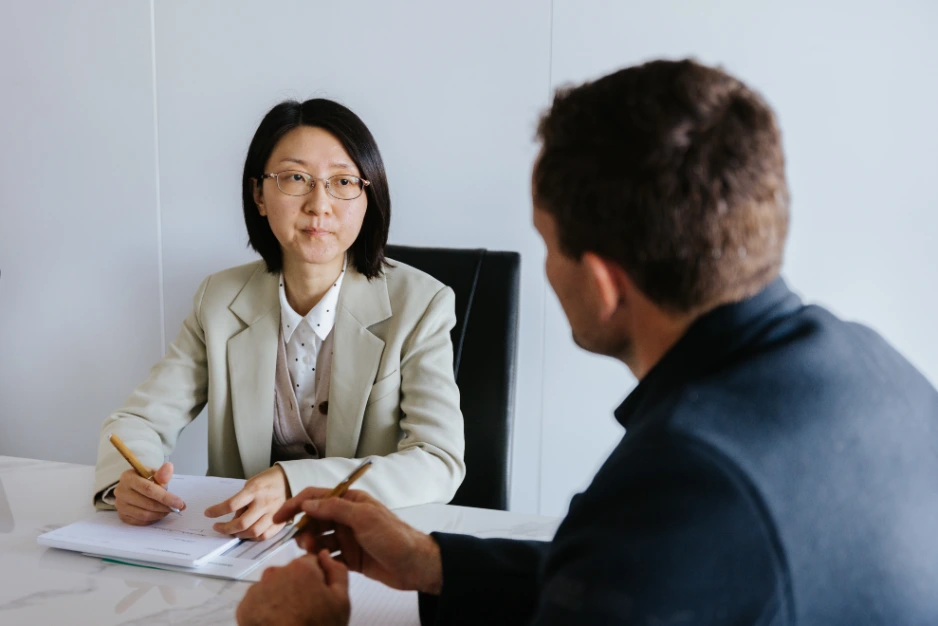 Female short haired legal expert listening to male client talk at table