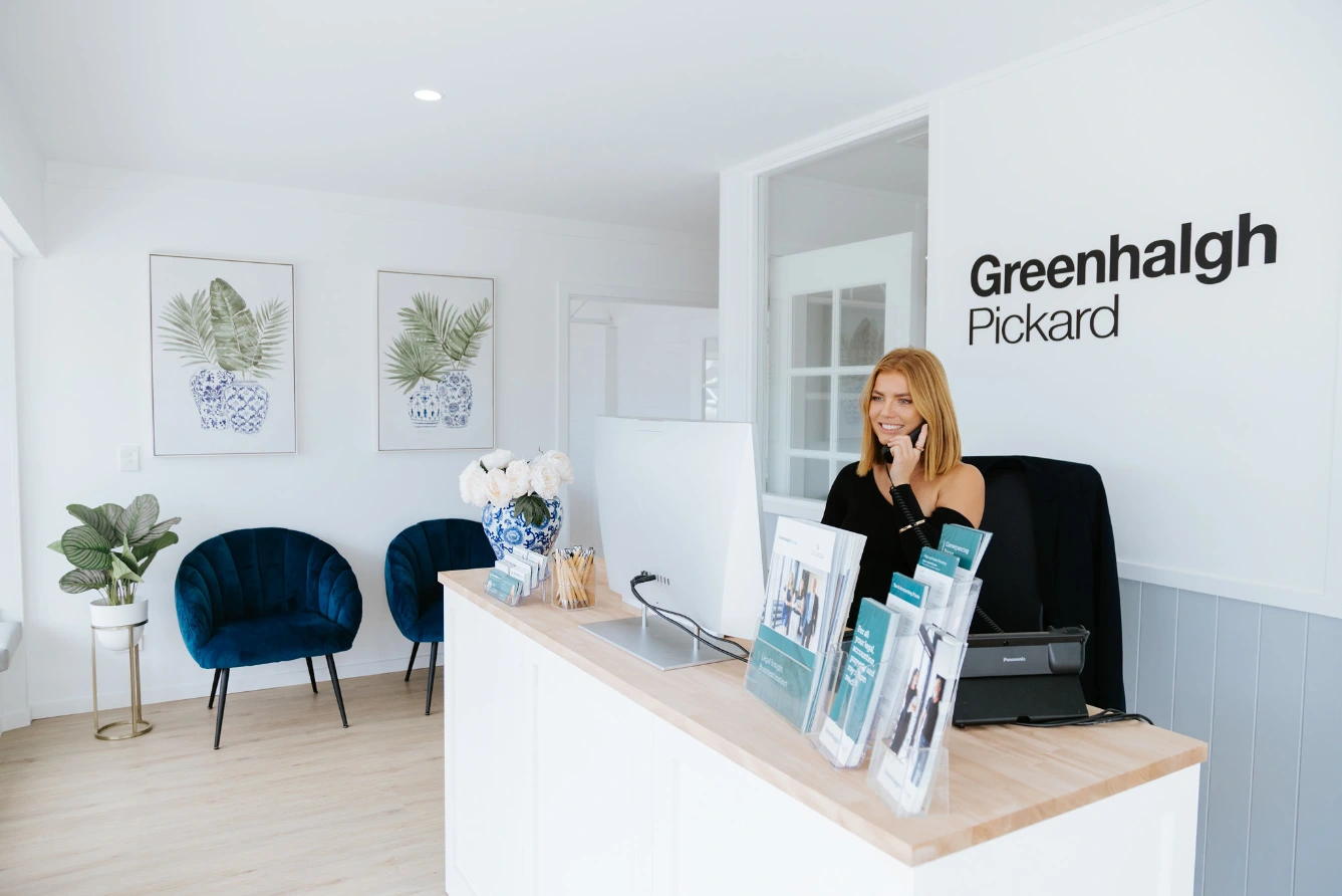 Smiling red haired receptionist answering phone in office