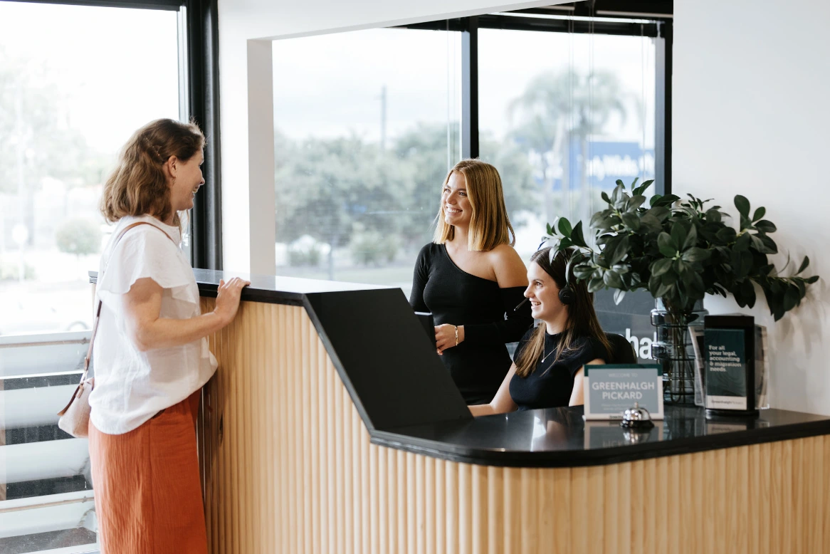 Red haired female accountant greeting client in office reception area