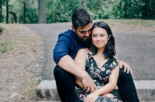 Smiling asian woman with husband hugging her