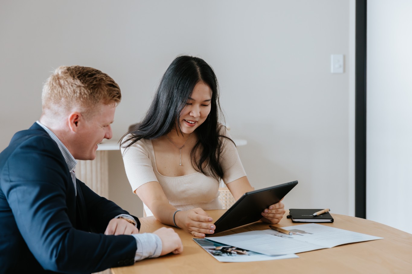 Red haired accountant talking to woman with long dark hair