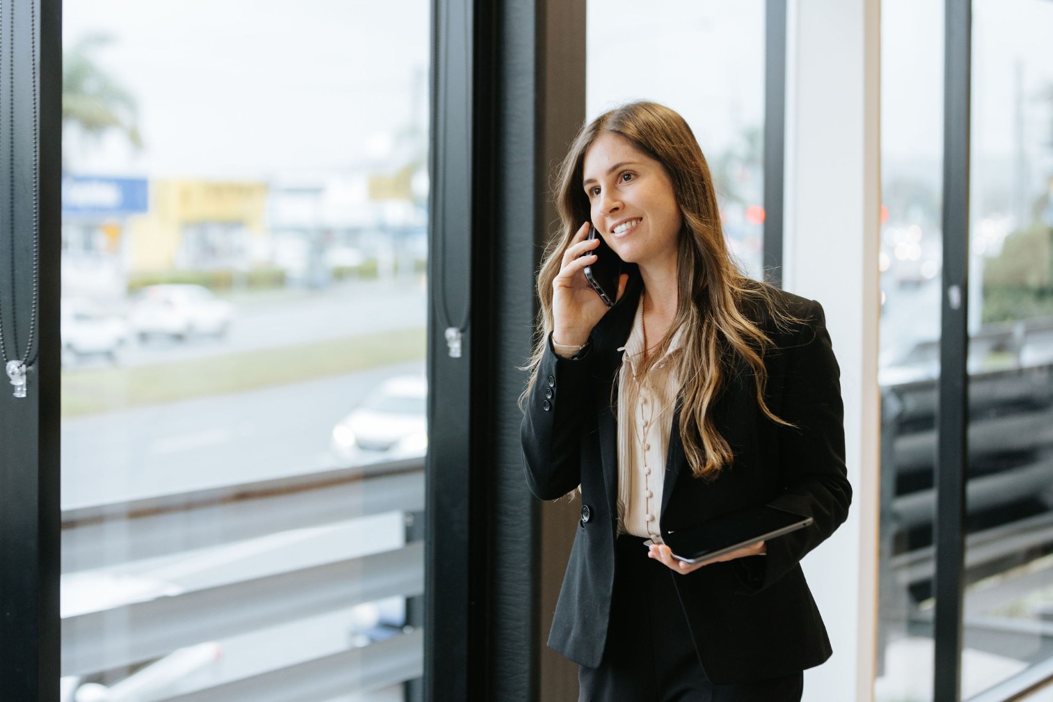 Smiling white female with long brunette hair. She is a legal professional in a business suit.